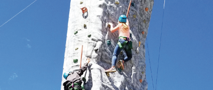 West Grand youth scale a climbing wall at a Colorado AeroLab summer camp.