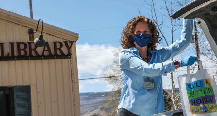 photo by Mike Wilson | Shelly Mathisplaces the requested library materials into the trunk of pat ron’s car.
